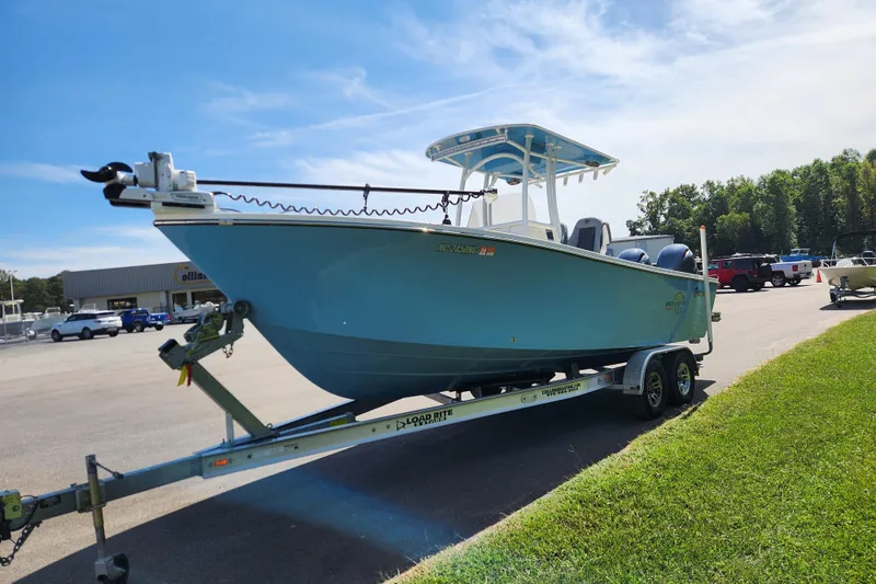 Slide: The Image of 2025 May-Craft 245 Offshore CC boat on trailer, parked outdoors under clear sky. - 7