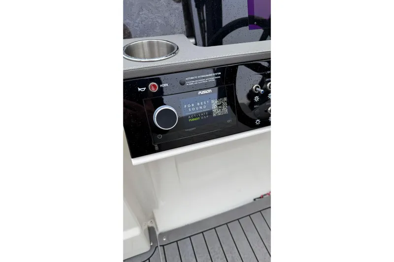 Slide: The Image of 2021 Sea Ray SDX 250 dashboard with Fusion audio system and controls. - 10