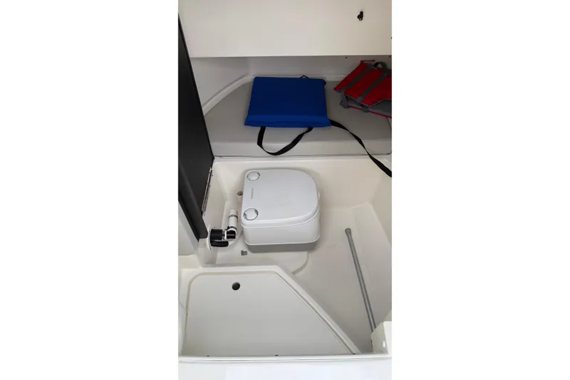Slide: The Image of 2021 Sea Ray SDX 250 boat interior with portable toilet and storage area. - 15