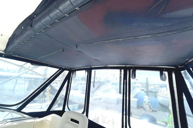 Slide: The Image of Interior view of 2003 Grady-White Express 330 boat with covered cockpit and marina background. - 12