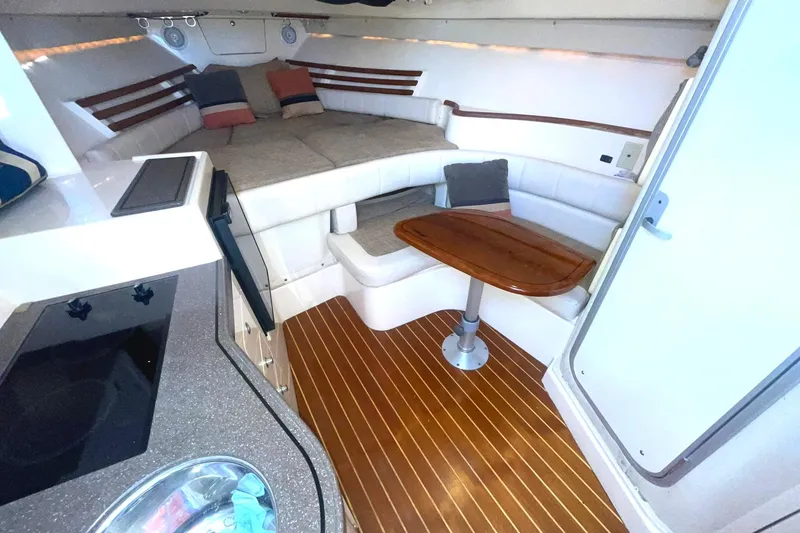 Slide: The Image of Interior of 2003 Grady-White Express 330 boat with cozy seating and wooden table. - 19