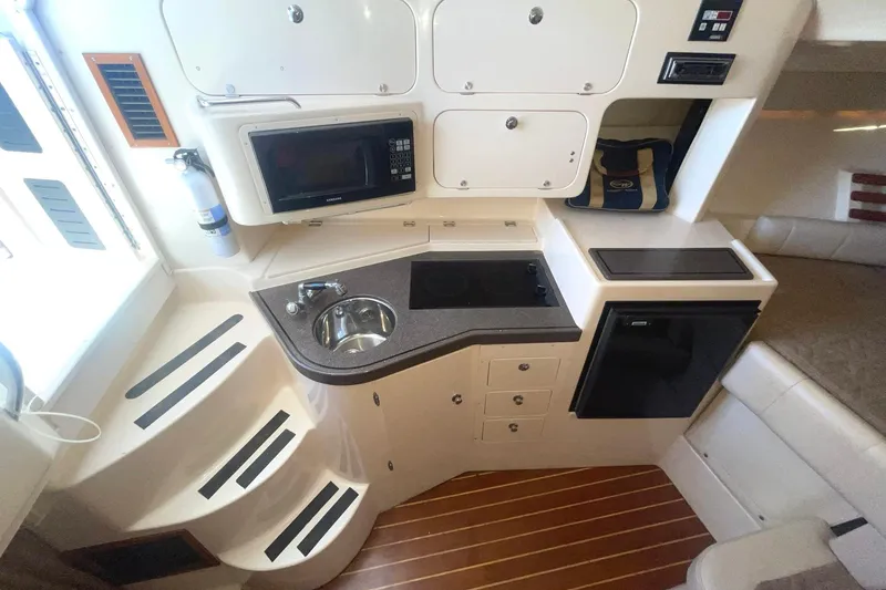 Slide: The Image of 2003 Grady-White Express 330 boat interior with kitchenette, microwave, sink, and compact fridge. - 25