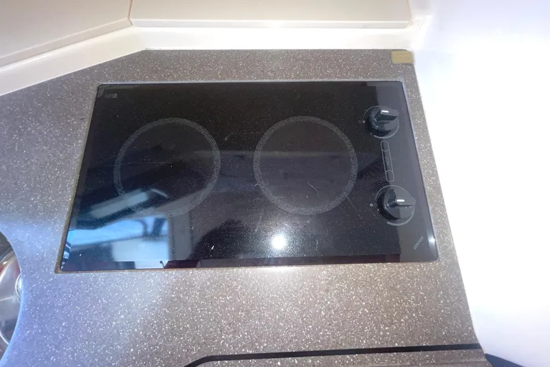 Slide: The Image of 2003 Grady-White Express 330 boat kitchen with a sleek black stovetop. - 26