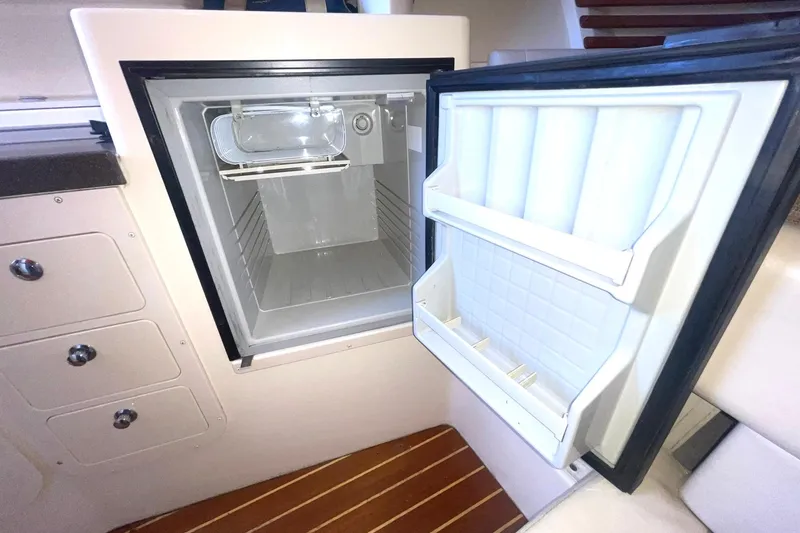 Slide: The Image of Open refrigerator inside 2003 Grady-White Express 330 boat, showcasing interior storage space. - 29