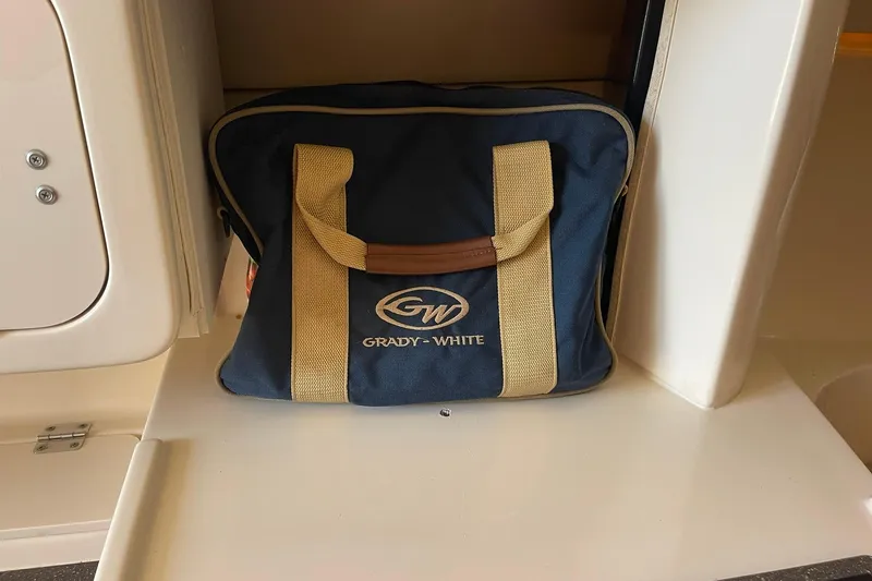 Slide: The Image of Grady-White branded bag on a 2003 Express 330 boat interior shelf. - 32