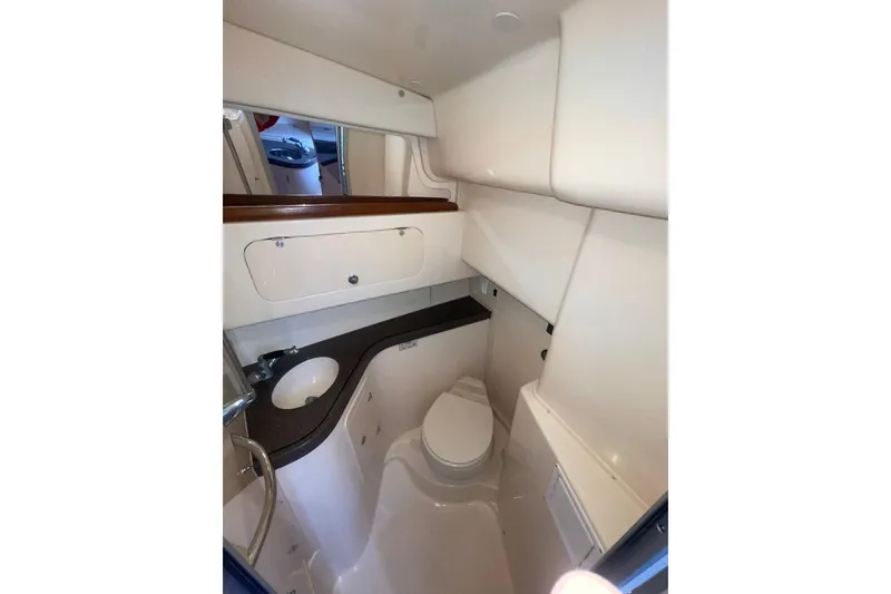 Slide: The Image of Compact bathroom in 2003 Grady-White Express 330 boat, featuring sink, toilet, and storage. - 33