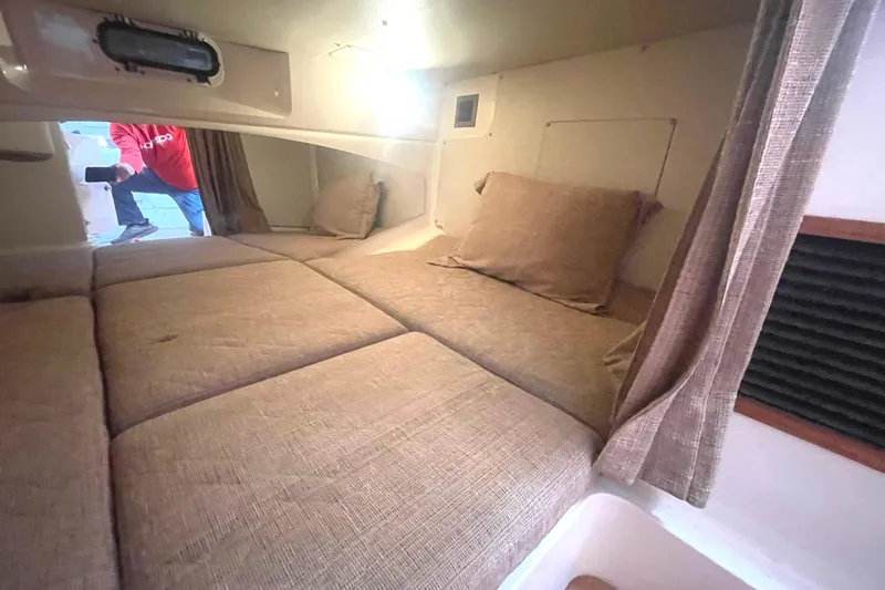Slide: The Image of 2003 Grady-White Express 330 cabin interior with beige cushions and curtains. - 34