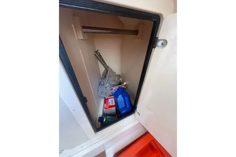 Slide: The Image of Storage compartment on 2003 Grady-White Express 330 boat with cleaning supplies and tools. - 35
