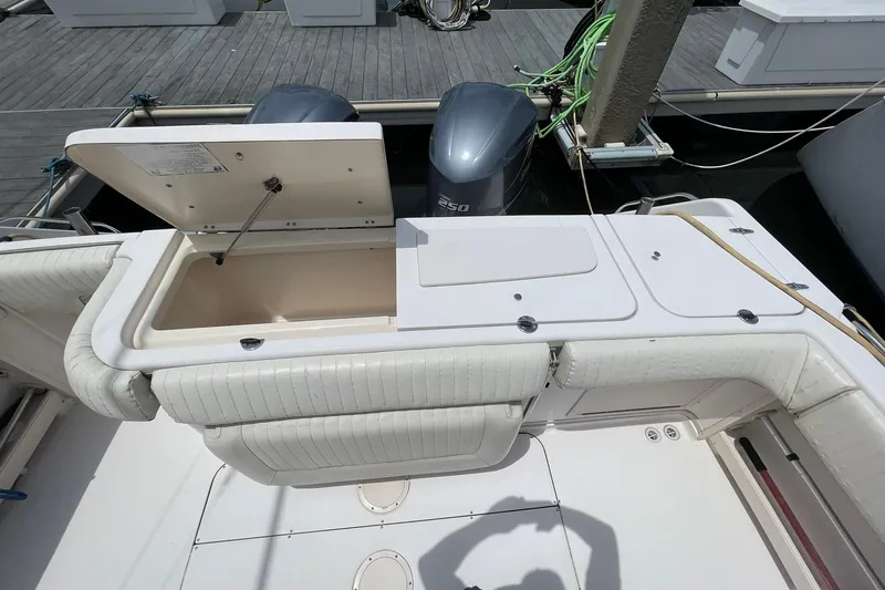 Slide: The Image of 2003 Grady-White Express 330 boat deck with open storage compartment and twin engines. - 5