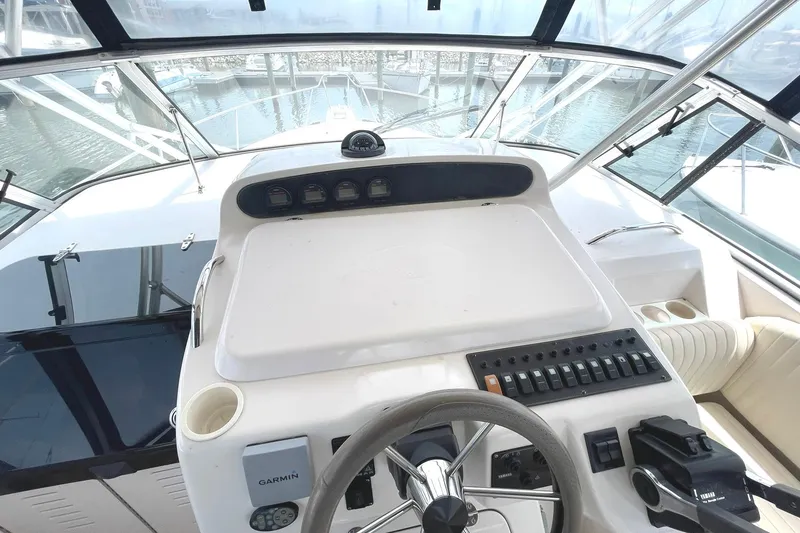 Slide: The Image of 2003 Grady-White Express 330 boat helm with steering wheel and navigation controls. - 9