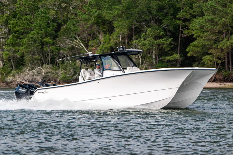 The Image of 2024 Front Runner 37 Catamaran cruising on water with forested background. - 1