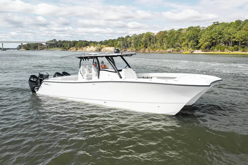 Slide: The Image of 2024 Front Runner 37 Catamaran cruising on a scenic river with lush green shoreline. - 2