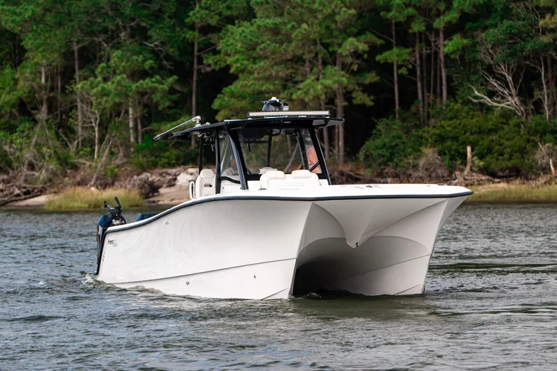 Slide: The Image of 2024 Front Runner 37 Catamaran cruising on a scenic river with lush forest backdrop. - 4