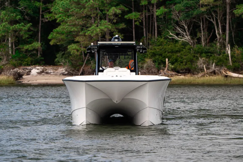 Slide: The Image of 2024 Front Runner 37 Catamaran cruising on a serene waterway with lush forest backdrop. - 5