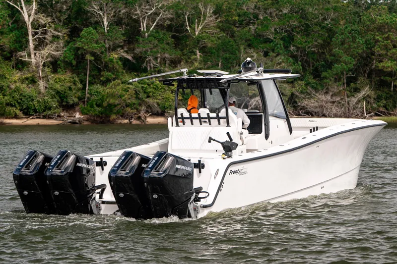 Slide: The Image of 2024 Front Runner 37 Catamaran with four Mercury engines cruising on a scenic waterway. - 7