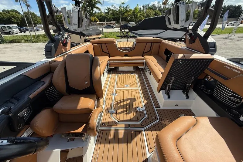 Slide: The Image of 2018 Nautique Super Air Nautique G25 Coastal Edition interior with tan seating and teak flooring. - 11