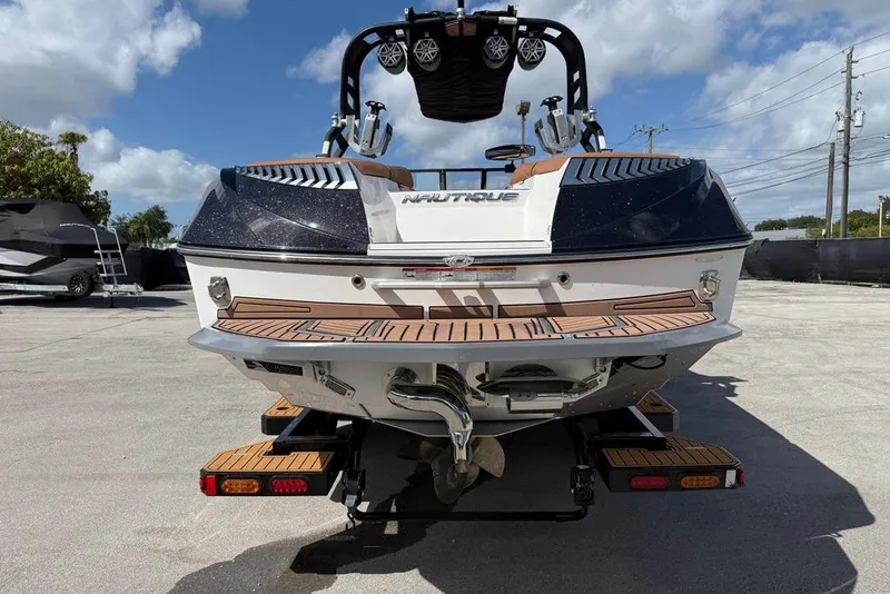 Slide: The Image of 2018 Nautique Super Air Nautique G25 Coastal Edition boat, rear view, parked outdoors. - 12