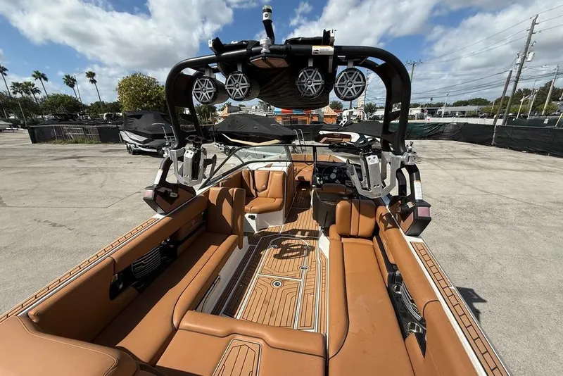 Slide: The Image of 2018 Nautique Super Air Nautique G25 Coastal Edition interior with tan seating and speakers. - 8