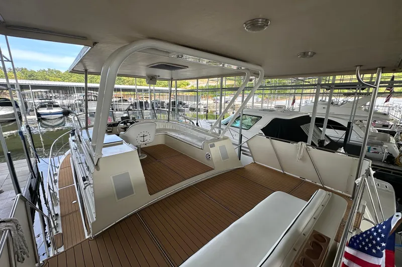 Slide: The Image of 1990 Blue Water 42 Coastal Cruiser docked, featuring spacious deck and helm area. - 16