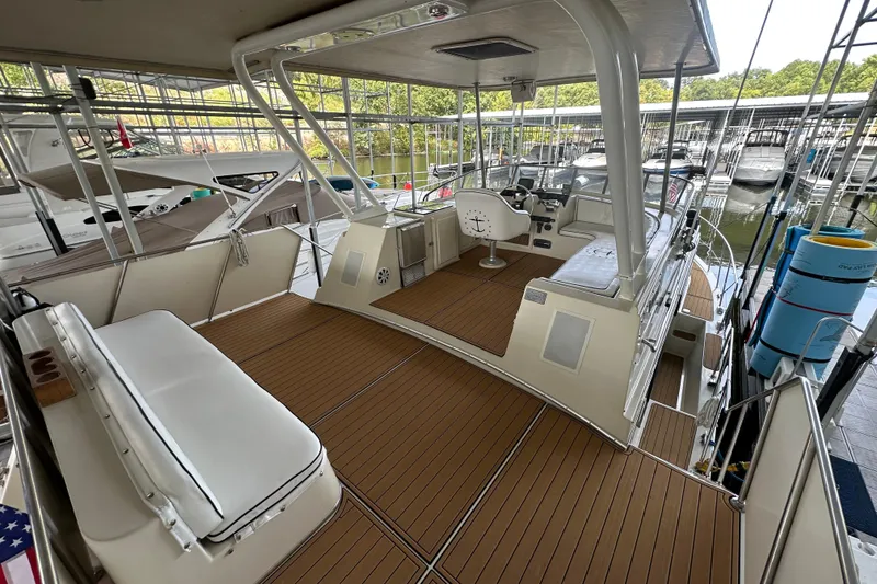 Slide: The Image of 1990 Blue Water 42 Coastal Cruiser with spacious deck and modern helm in marina setting. - 17