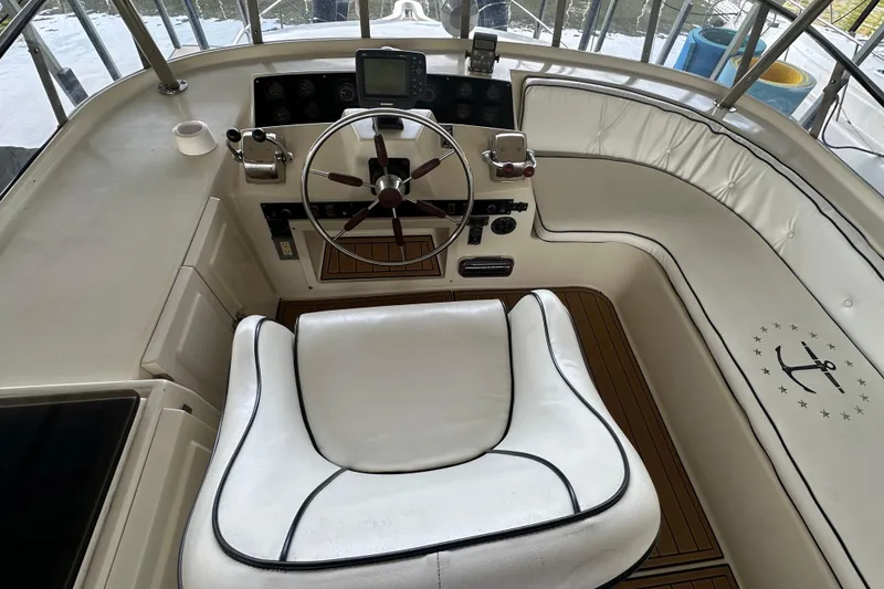 Slide: The Image of 1990 Blue Water 42 Coastal Cruiser helm with white seating and wooden accents. - 21