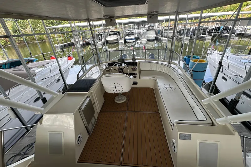 Slide: The Image of 1990 Blue Water 42 Coastal Cruiser interior with helm, seating, and docked boats in marina. - 28