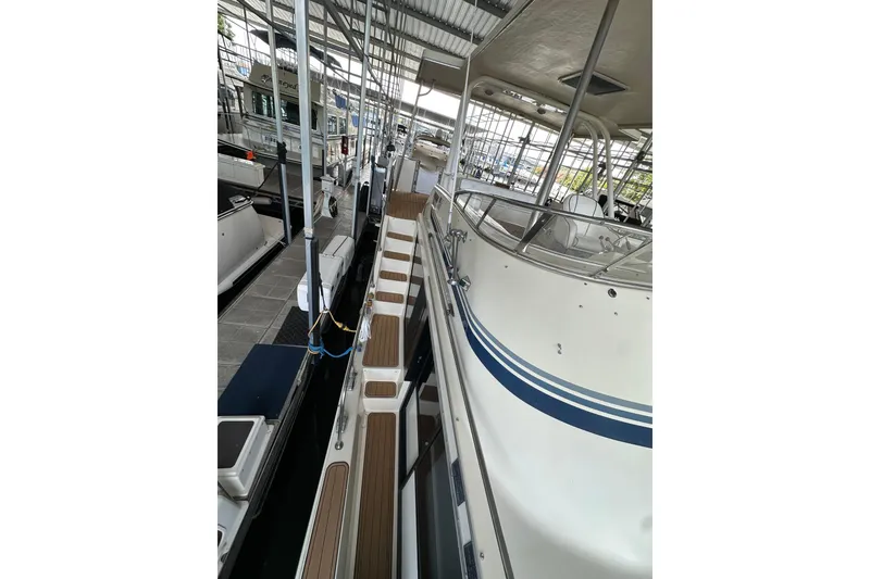 Slide: The Image of 1990 Blue Water 42 Coastal Cruiser docked in a marina, showcasing sleek design and spacious deck. - 29