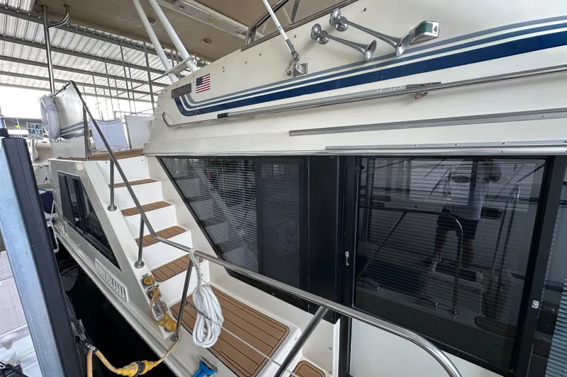 Slide: The Image of 1990 Blue Water 42 Coastal Cruiser docked, featuring stairs and sleek design elements. - 3