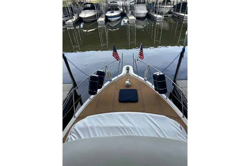 Slide: The Image of Bow view of 1990 Blue Water 42 Coastal Cruiser docked at marina with American flags. - 30