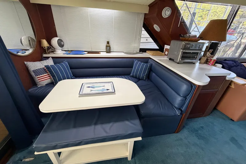 Slide: The Image of Interior of 1990 Blue Water 42 Coastal Cruiser with blue seating and dining area. - 37
