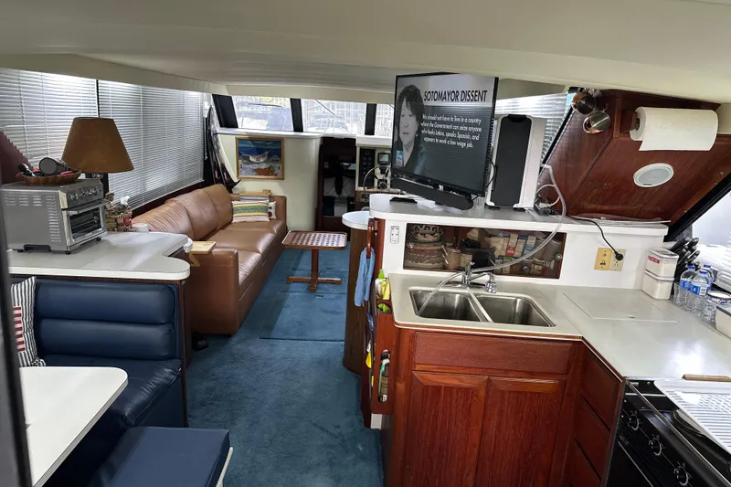 Slide: The Image of Interior of 1990 Blue Water 42 Coastal Cruiser with kitchen, seating, and TV. - 42