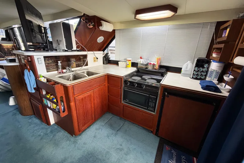 Slide: The Image of Cozy kitchen in 1990 Blue Water 42 Coastal Cruiser with wood cabinetry and modern appliances. - 43