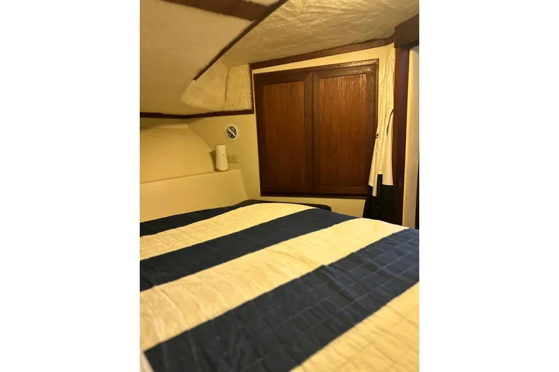 Slide: The Image of Cozy cabin interior of 1990 Blue Water 42 Coastal Cruiser with striped bedding. - 59