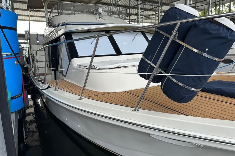 Slide: The Image of 1990 Blue Water 42 Coastal Cruiser docked, featuring sleek design and wooden deck. - 6