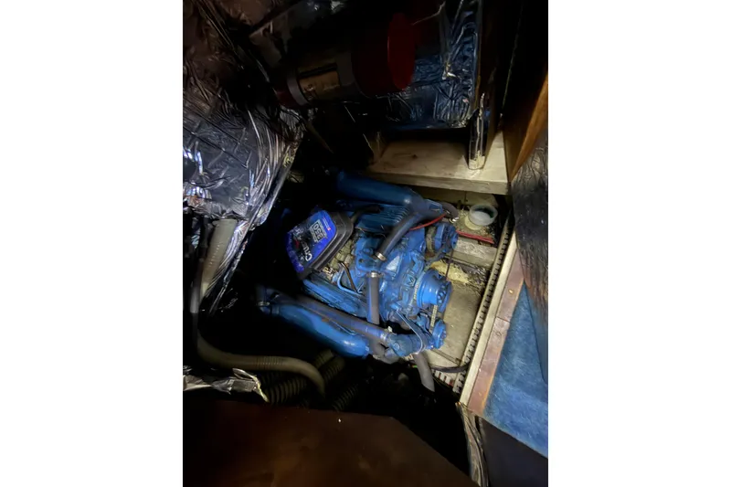 Slide: The Image of Engine compartment of 1990 Blue Water 42 Coastal Cruiser, featuring a blue marine engine. - 63