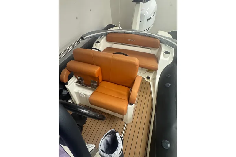 Slide: The Image of 2020 Brig Eagle 6.7 boat interior with tan leather seats and wood flooring. - 11
