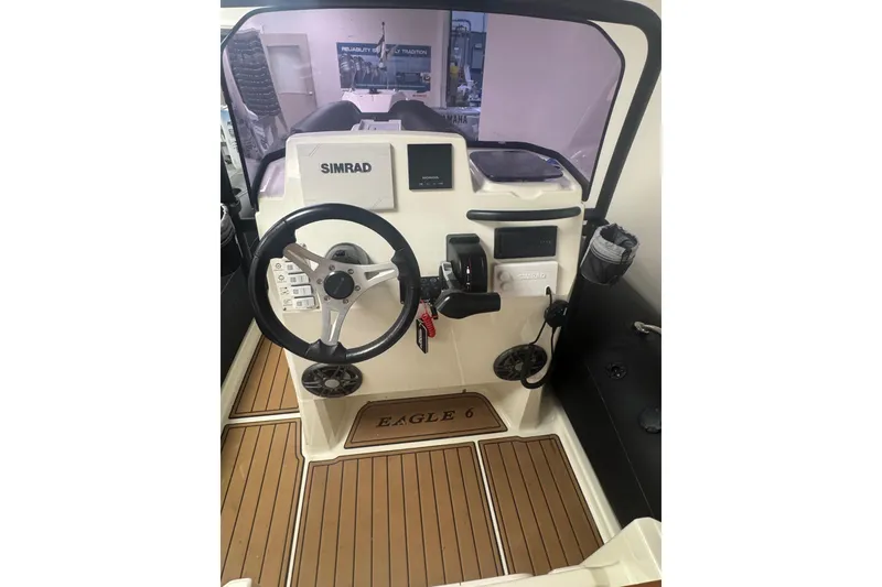 Slide: The Image of 2020 Brig Eagle 6.7 boat cockpit with Simrad navigation system and wooden flooring. - 8