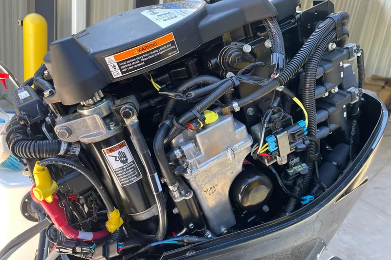 Slide: The Image of Close-up of a 2021 Boston Whaler 150 Montauk boat engine, showcasing intricate wiring and components. - 12