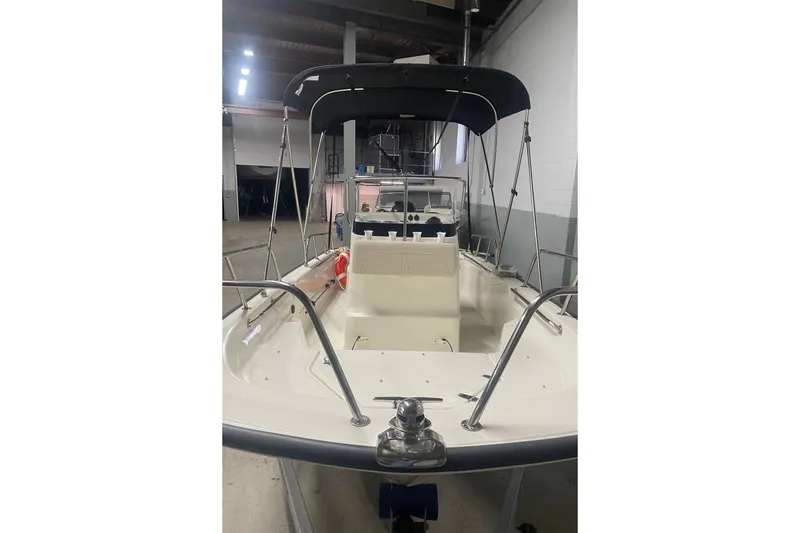 Slide: The Image of 2021 Boston Whaler 150 Montauk boat with canopy in a garage setting. - 15