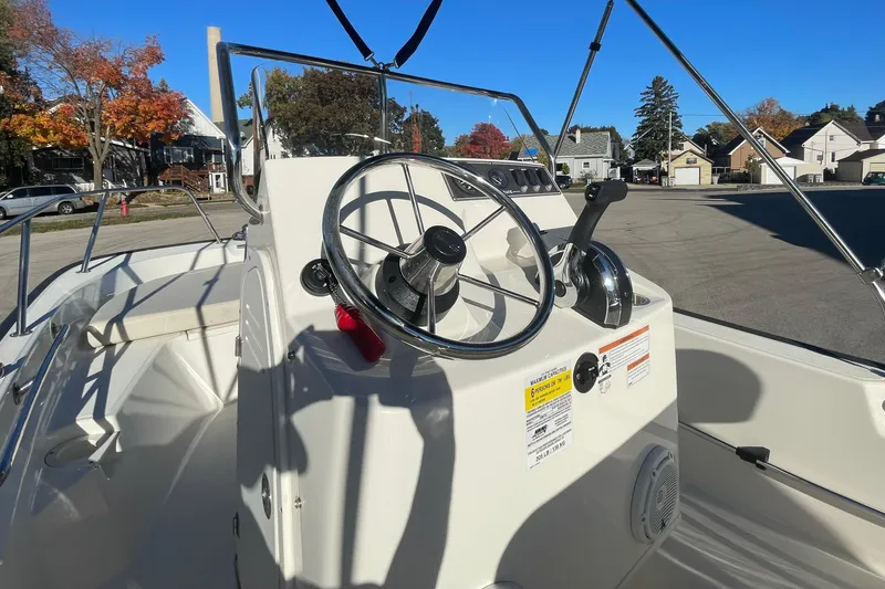 Slide: The Image of 2021 Boston Whaler 150 Montauk boat console with steering wheel and controls. - 5