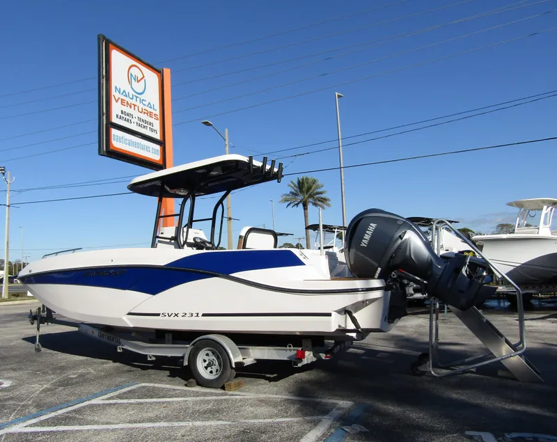 Slide: The Image of 2024 Starcraft SVX 231 OB CC boat on trailer at Nautical Ventures dealership. - 1