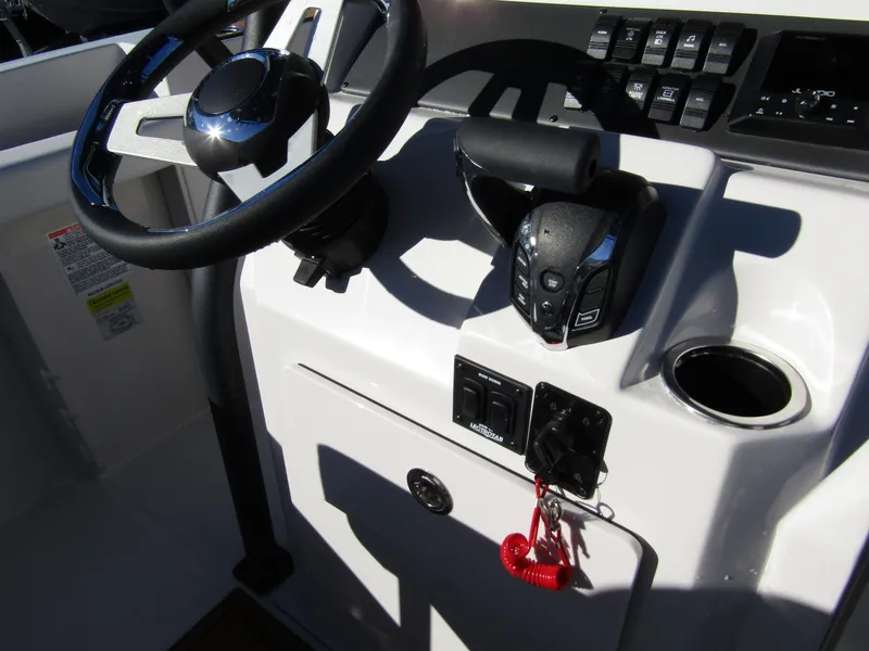 Slide: The Image of 2024 Starcraft SVX 231 OB CC boat console with steering wheel and controls. - 22