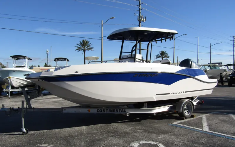 Slide: The Image of 2024 Starcraft SVX 231 OB CC boat on a trailer in a parking lot. - 6