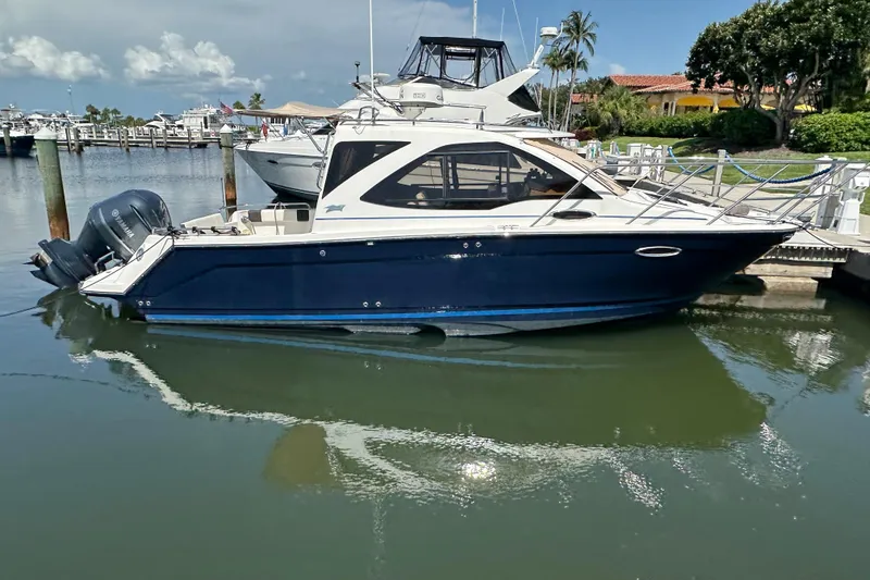 The Image of 2016 Cutwater C-24 Coupe boat docked in a marina, featuring a sleek blue hull. - 0