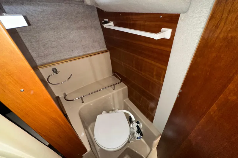 Slide: The Image of 2016 Cutwater C-24 Coupe boat bathroom with toilet and wooden paneling. - 15