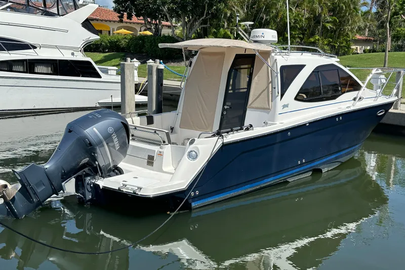 Slide: The Image of 2016 Cutwater C-24 Coupe boat docked, featuring a Yamaha outboard motor. - 2