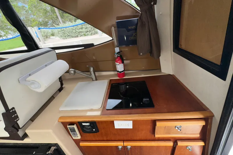 Slide: The Image of 2016 Cutwater C-24 Coupe interior kitchen with sink, stove, and fire extinguisher. - 5