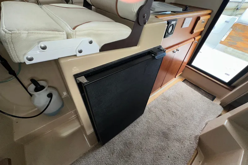 Slide: The Image of Interior of 2016 Cutwater C-24 Coupe featuring compact kitchen area with fridge and cabinets. - 8