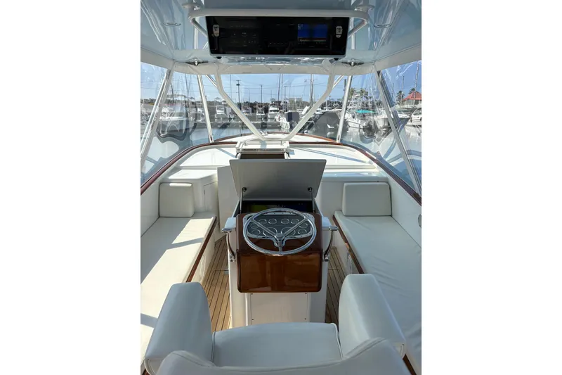 Slide: The Image of 2007 Gamefisherman 42 Walkaround helm with steering wheel and controls, docked in marina. - 19