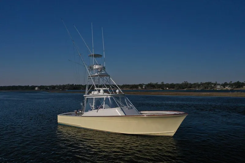 Slide: The Image of 2007 Gamefisherman 42 Walkaround boat with spacious deck, docked near another vessel. - 3
